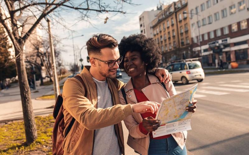 a man and woman looking at a map in the city