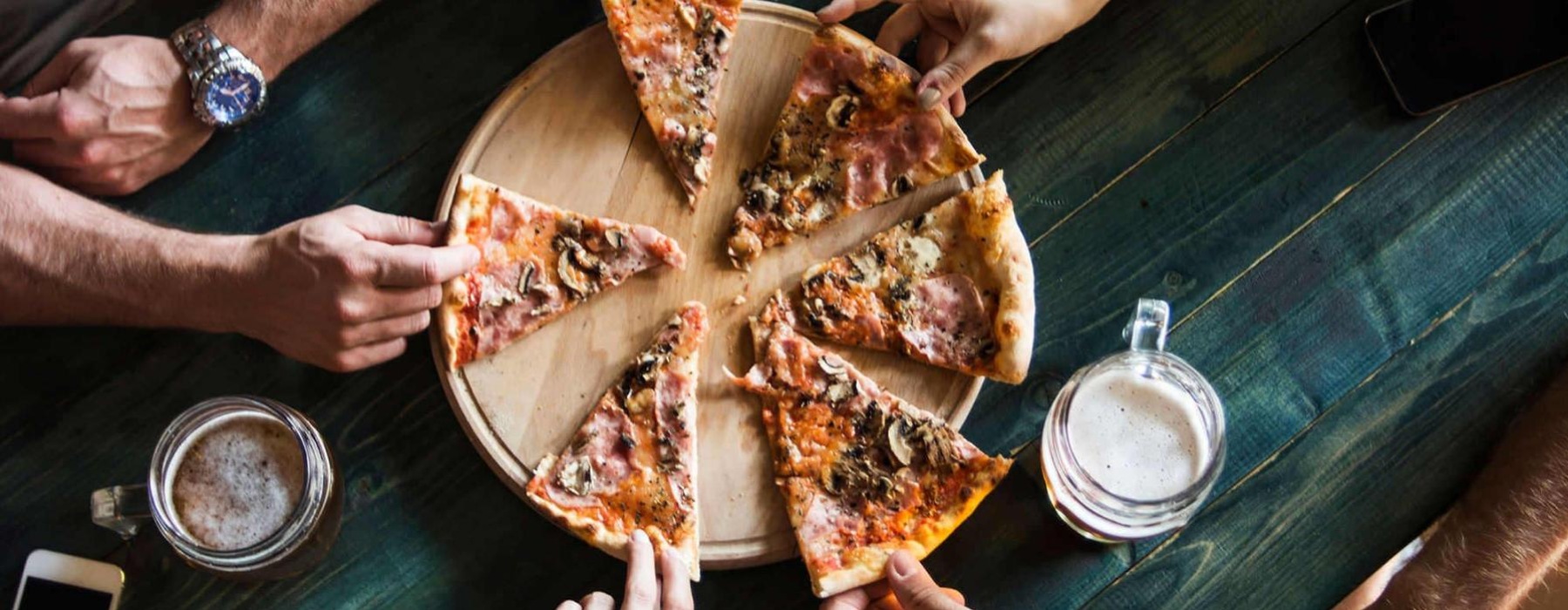 a group of people eating pizza